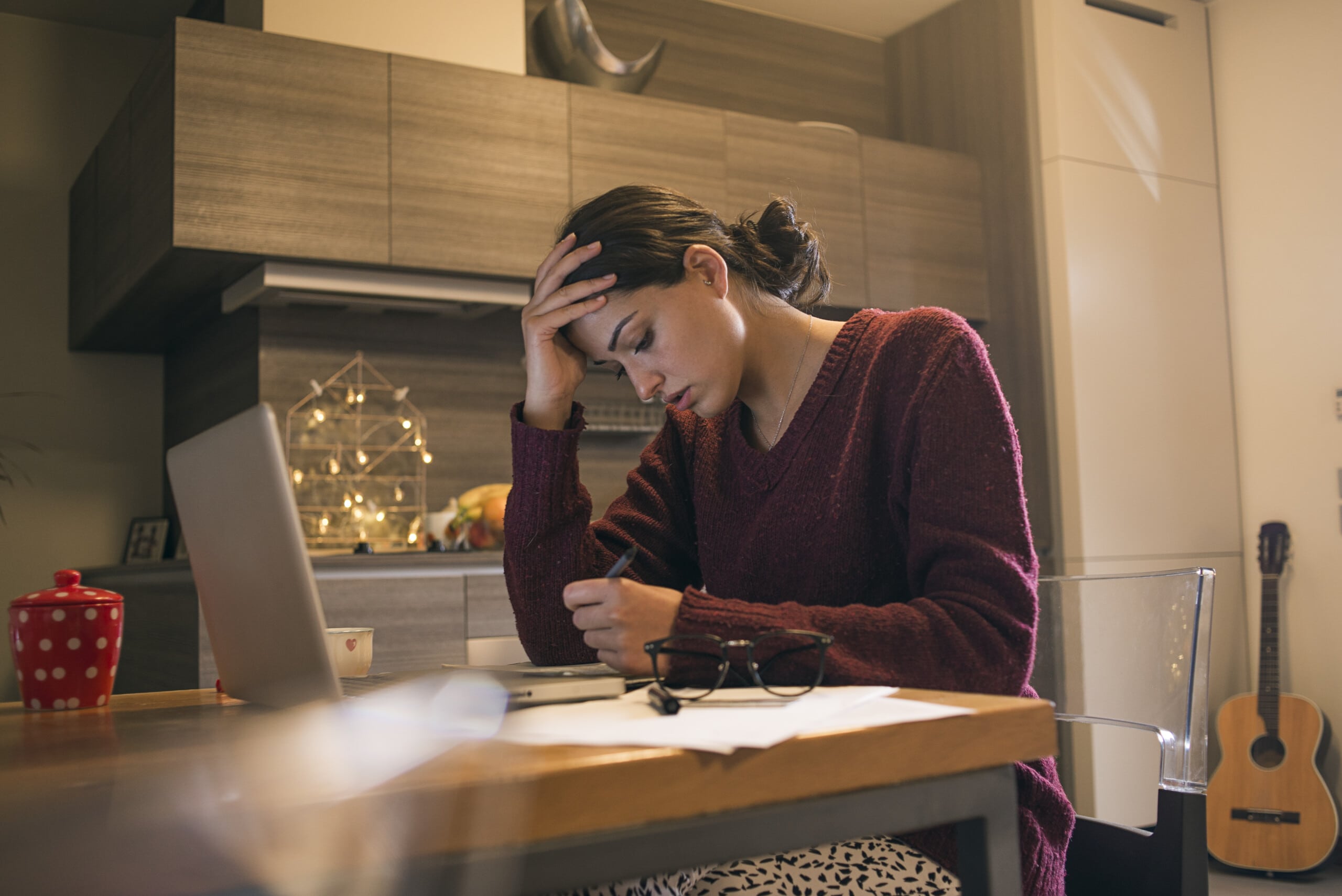 young woman at table reviewing monthly finances